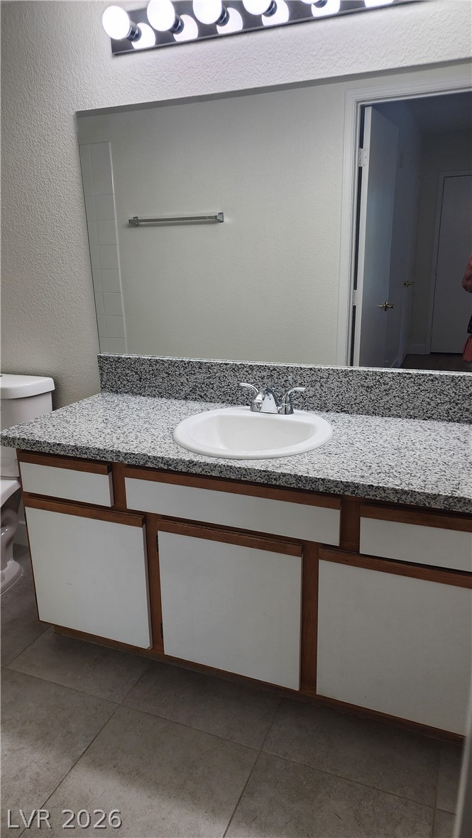 6650 West Warm Springs Road, Unit 2118 Las Vegas, NV 89118 - Photo 37 of 41 A well-lit vanity with a stone countertop and spacious cabinetry awaits in this functional bathroom.