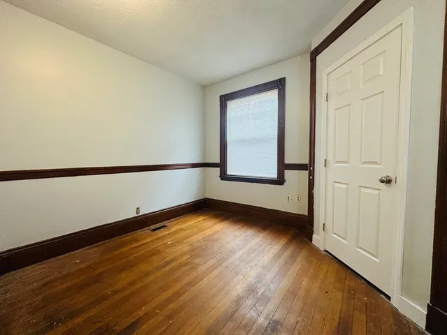 a view of a room with wooden floor and window