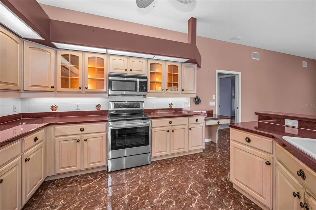 11917 Hadleigh Way Trinity, FL 34655 - Photo 19 of 84 a kitchen with granite countertop a stove sink and cabinets