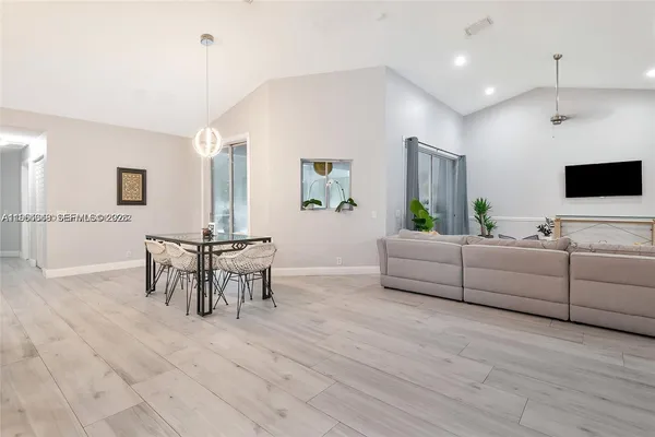 a living room with furniture a flat screen tv and a window