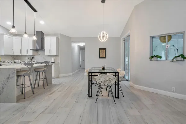 a kitchen with a table chairs a sink dishwasher stove and cabinets