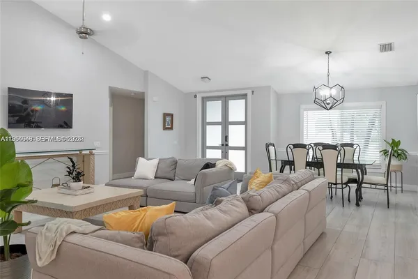 a kitchen with stainless steel appliances a sink a stove a table and chairs