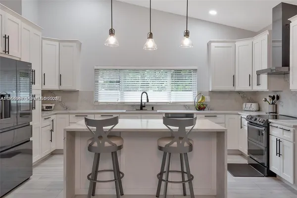 a kitchen with a sink stainless steel appliances and white cabinets