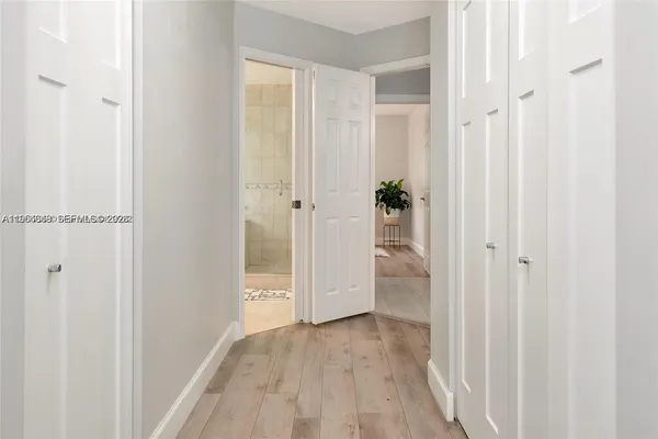 a bedroom with a bed a dresser and wooden floor