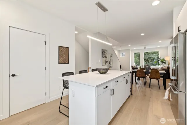 a large white kitchen with a stove a sink a table and chairs