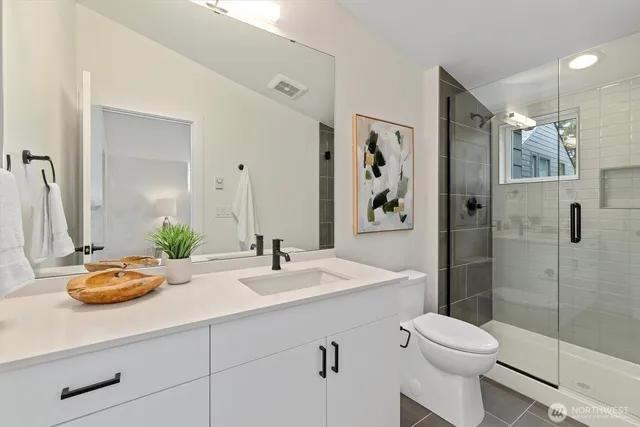 a bathroom with a sink a toilet and shower