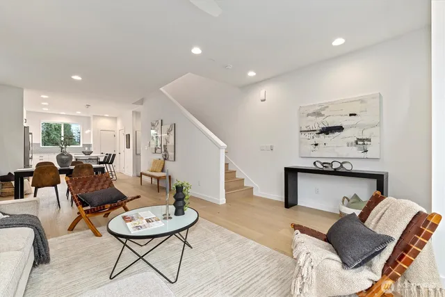 a living room with furniture a table and kitchen view