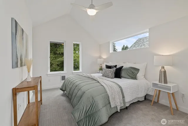 a bedroom with a bed a window and potted plant on the dresser
