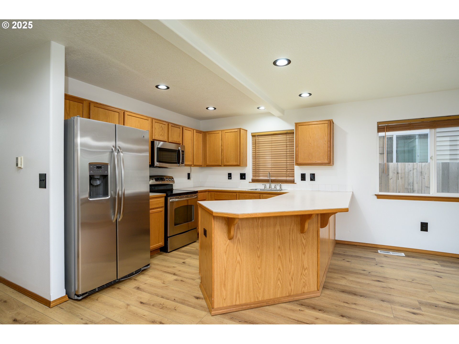 1306 Parkside Lane Newberg, OR 97132 - Photo 6 of 48 a large kitchen with stainless steel appliances kitchen island granite countertop a large kitchen island a stove a refrigerator a sink and dishwasher with wooden floor
