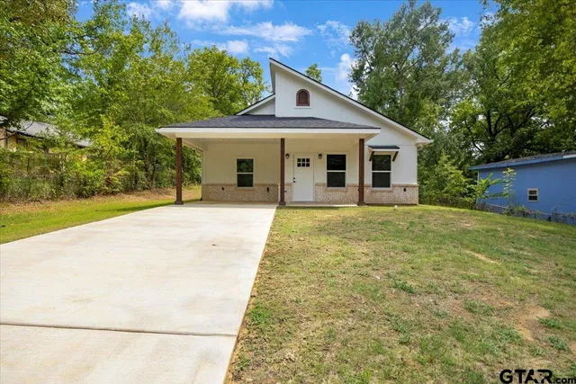 a front view of house with yard and trees around