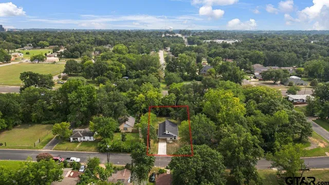 an aerial view of residential houses with outdoor space and trees