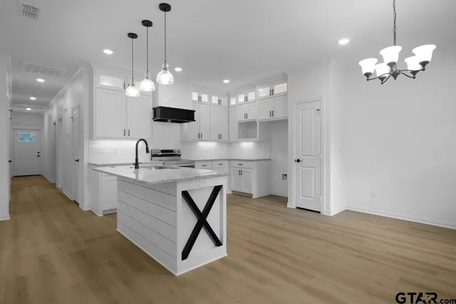 a bathroom with a sink chandelier and a view of kitchen