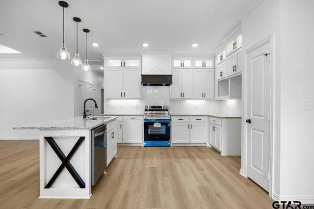 a kitchen with a sink cabinets and stainless steel appliances