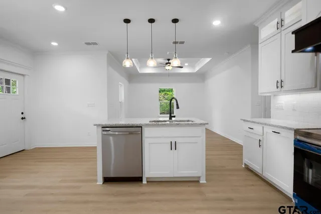 a kitchen with kitchen island a sink stainless steel appliances and cabinets