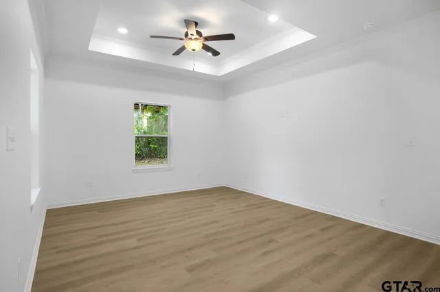 an empty room with a window and a fan
