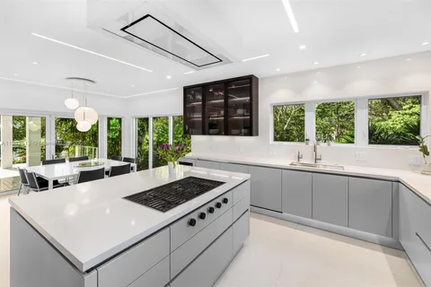 a living room with furniture a large window and potted plants