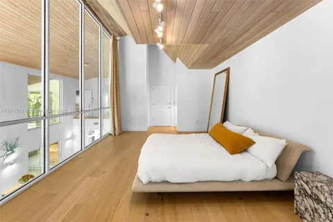 a bedroom with a bed and a wooden floor