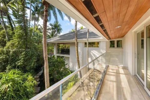 a view of swimming pool with seating space and trees in the background