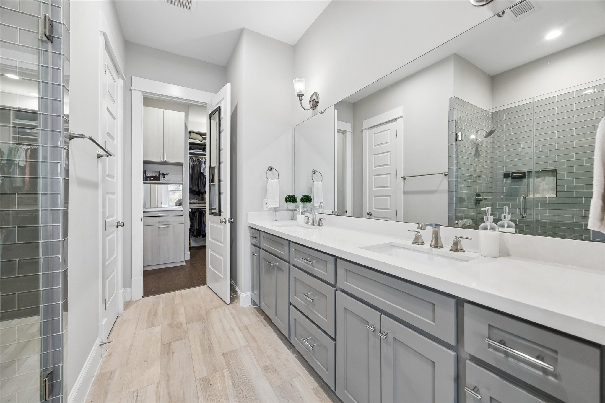 2913 Hicks Street Houston, TX 77007 - Photo 19 of 28 The spa-inspired primary bath features dual vanities, oversized mirrors, designer lighting, and a spacious glass-enclosed shower with timeless tile selections.