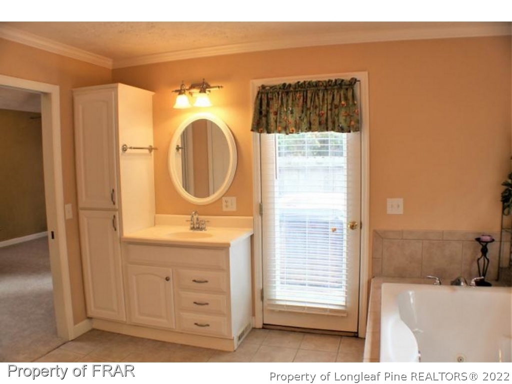 245 Fieldcrest Road Southern Pines, NC 28387 - Photo 14 of 26 a bathroom with a sink a mirror and a shower