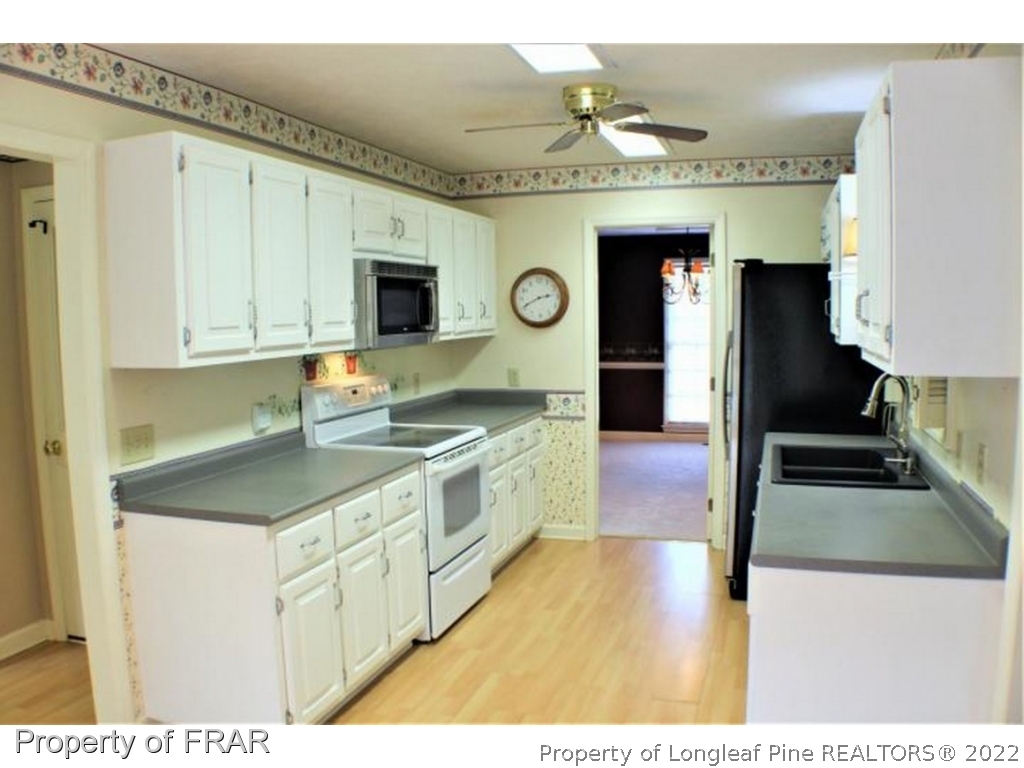 245 Fieldcrest Road Southern Pines, NC 28387 - Photo 6 of 26 a kitchen with stainless steel appliances granite countertop a sink and a stove