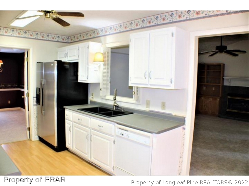 245 Fieldcrest Road Southern Pines, NC 28387 - Photo 7 of 26 a kitchen with a sink a refrigerator and cabinets