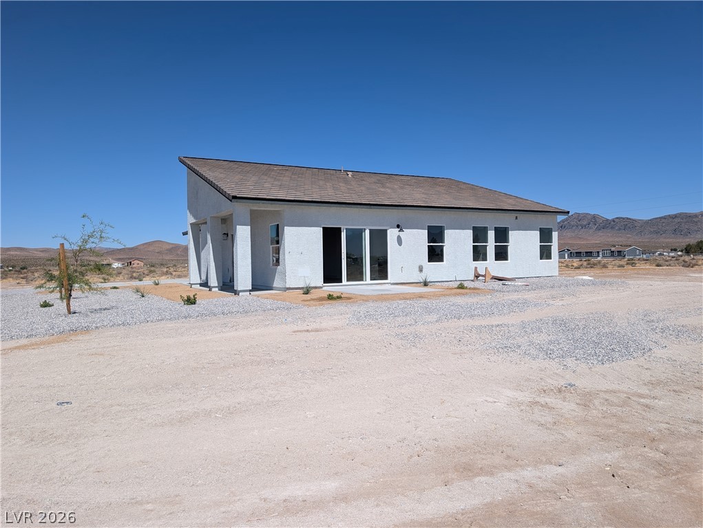 4670 Medicine Man Road Pahrump, NV 89048 - Photo 3 of 36 A contemporary single-story residence is situated amidst a vast, open landscape with distant mountains under an expansive sky.