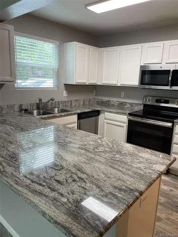 a kitchen with stainless steel appliances granite countertop a sink stove and microwave