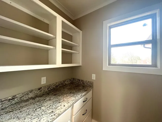 a kitchen with a granite countertop sink and cabinets