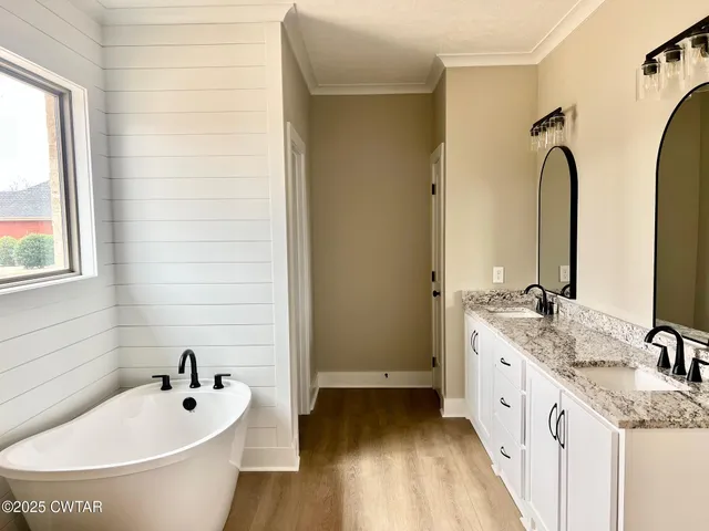 a bathroom with a granite countertop sink and a bathtub