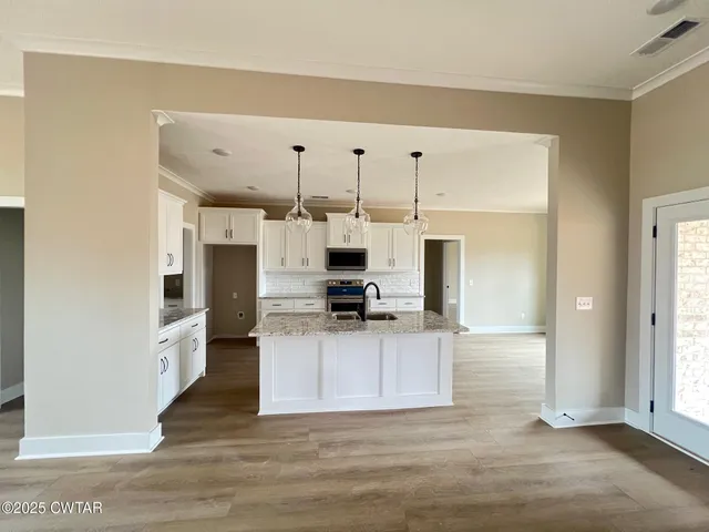 a kitchen with stainless steel appliances kitchen island granite countertop a refrigerator and a stove top oven