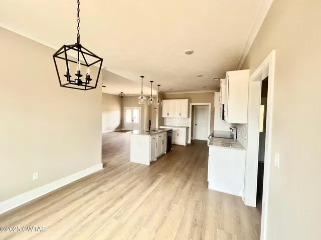 a view of a kitchen with a sink and dishwasher with wooden floor