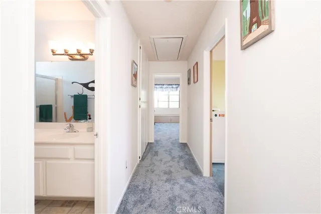 a view of a hallway with bathroom and shower