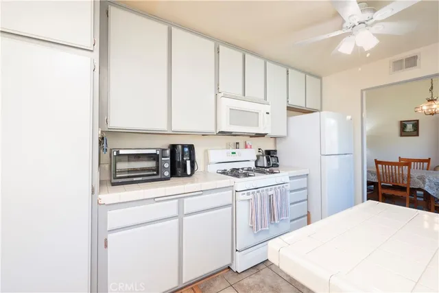 a kitchen with white cabinets and white appliances