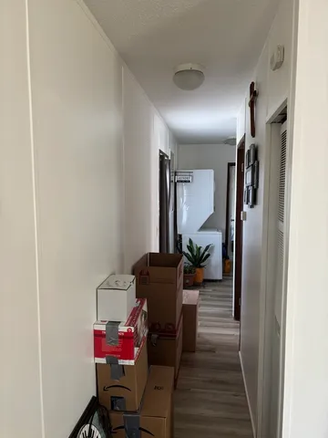 a view of a hallway with furniture and a window