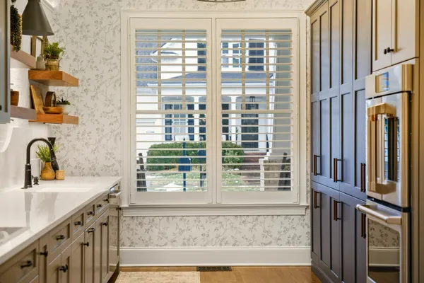 a large white kitchen with a sink and dishwasher a refrigerator with wooden floor