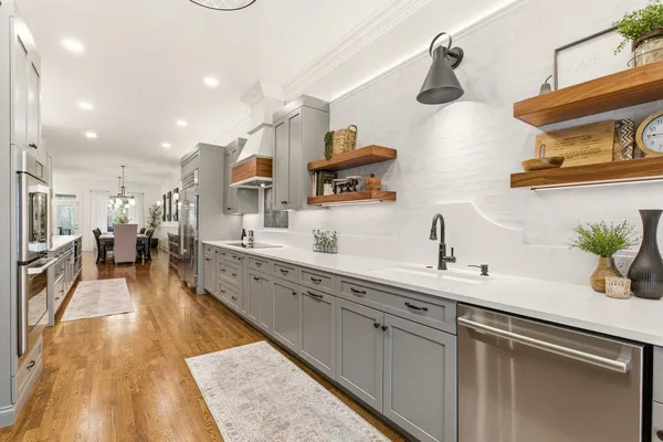 a large kitchen with stainless steel appliances lots of counter space and a sink
