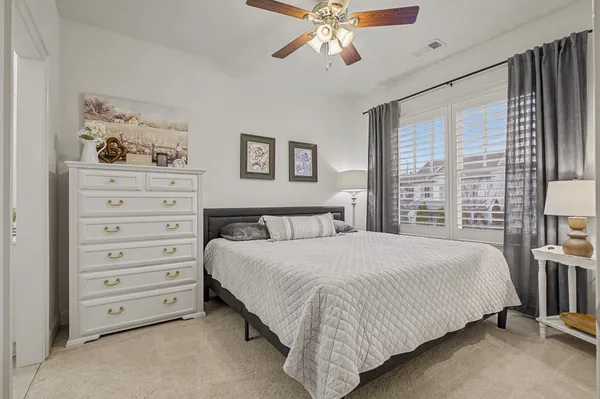 a view of a backyard with table and chairs potted plants and large tree