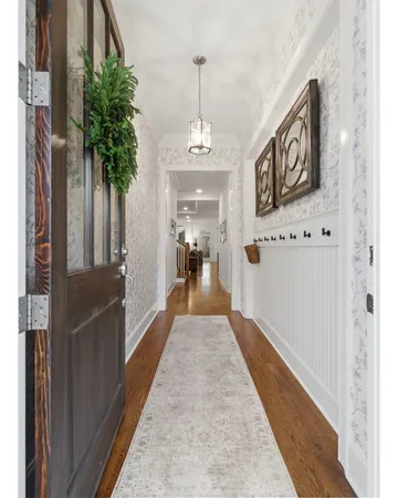 a view of a hallway with wooden floor and staircase