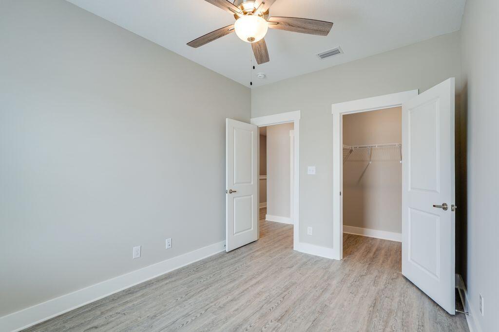 98 Date Palm Lane Freeport, FL 32439 - Photo 4 of 12 an empty room with wooden floor and ceiling fan