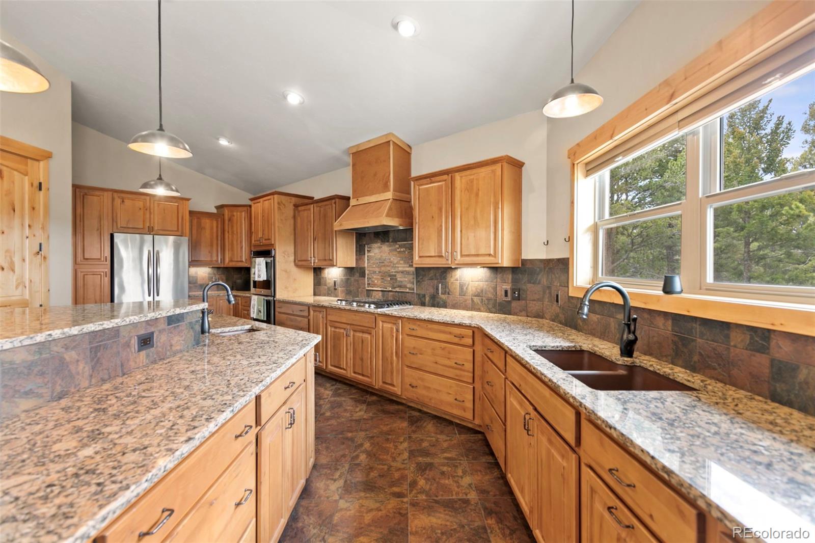 252 Running Elk Point Divide, CO 80814 - Photo 22 of 50 a kitchen with stainless steel appliances granite countertop a sink a stove and a wooden cabinets