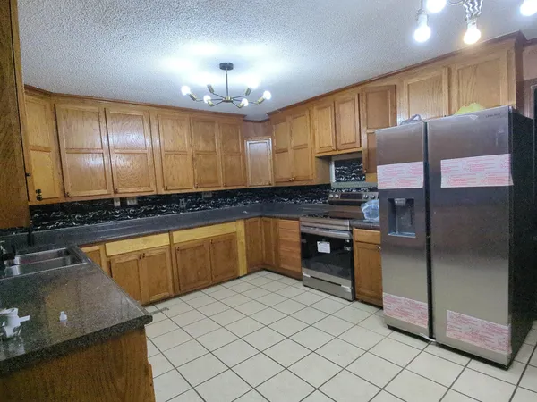 a kitchen with stainless steel appliances granite countertop a sink counter space cabinets and a large window