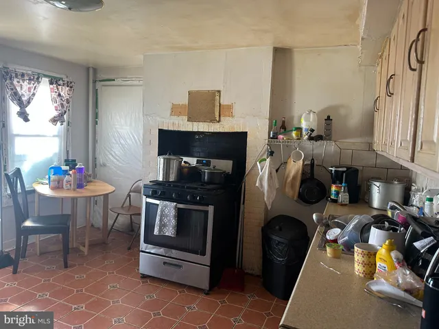 a kitchen with a stove a refrigerator and a dining table
