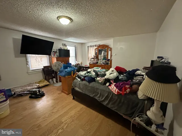 a living room with furniture a flat screen tv and gym equipment