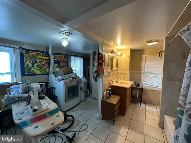 a large living room with stainless steel appliances furniture a rug and a view of kitchen