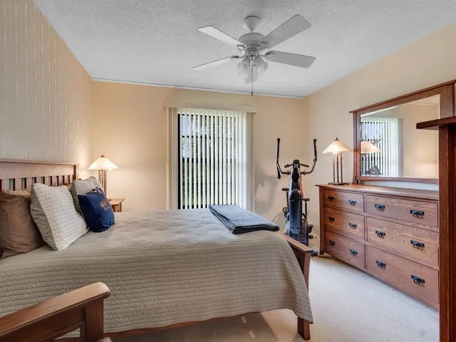 a bedroom with a bed a chandelier and dresser