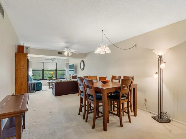 a view of a dining room and livingroom with furniture wooden floor and a rug