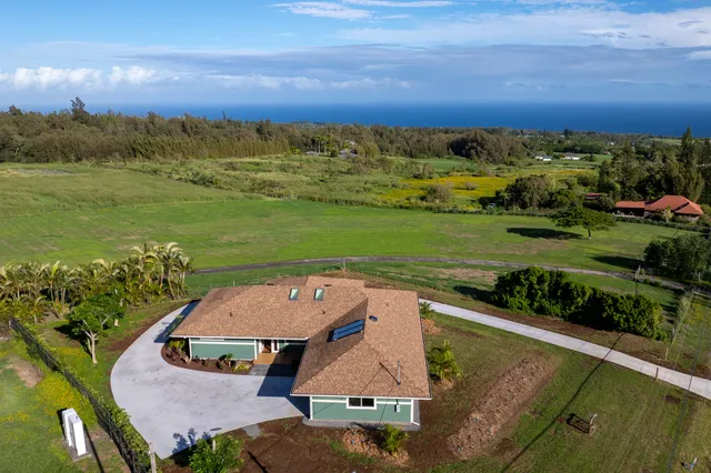 an aerial view of a house with a garden and mountain view