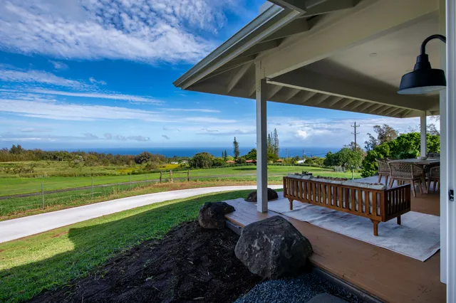 a view of a roof deck with chair and wooden fence