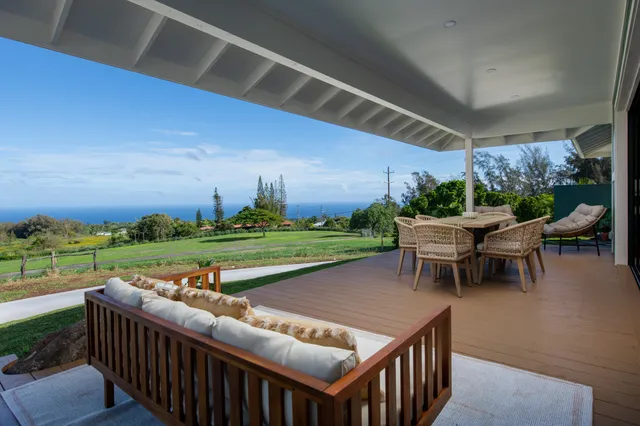 a view of a chairs and table in patio with swimming pool and yard
